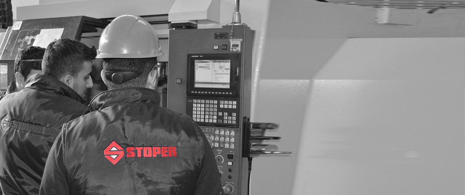 Stoper Endüstriyel üretim tesisinde CNC tezgâhının kontrol paneli başında iki teknisyen